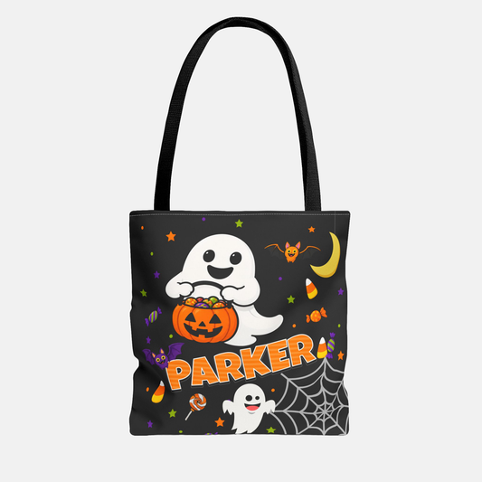 A black tote bag with a Halloween-themed graphic print featuring a white cartoon ghost holding an orange jack-o'-lantern, the name 'PARKER' in orange, candy corn, a bat, spiderwebs, and stars on a light gray background.