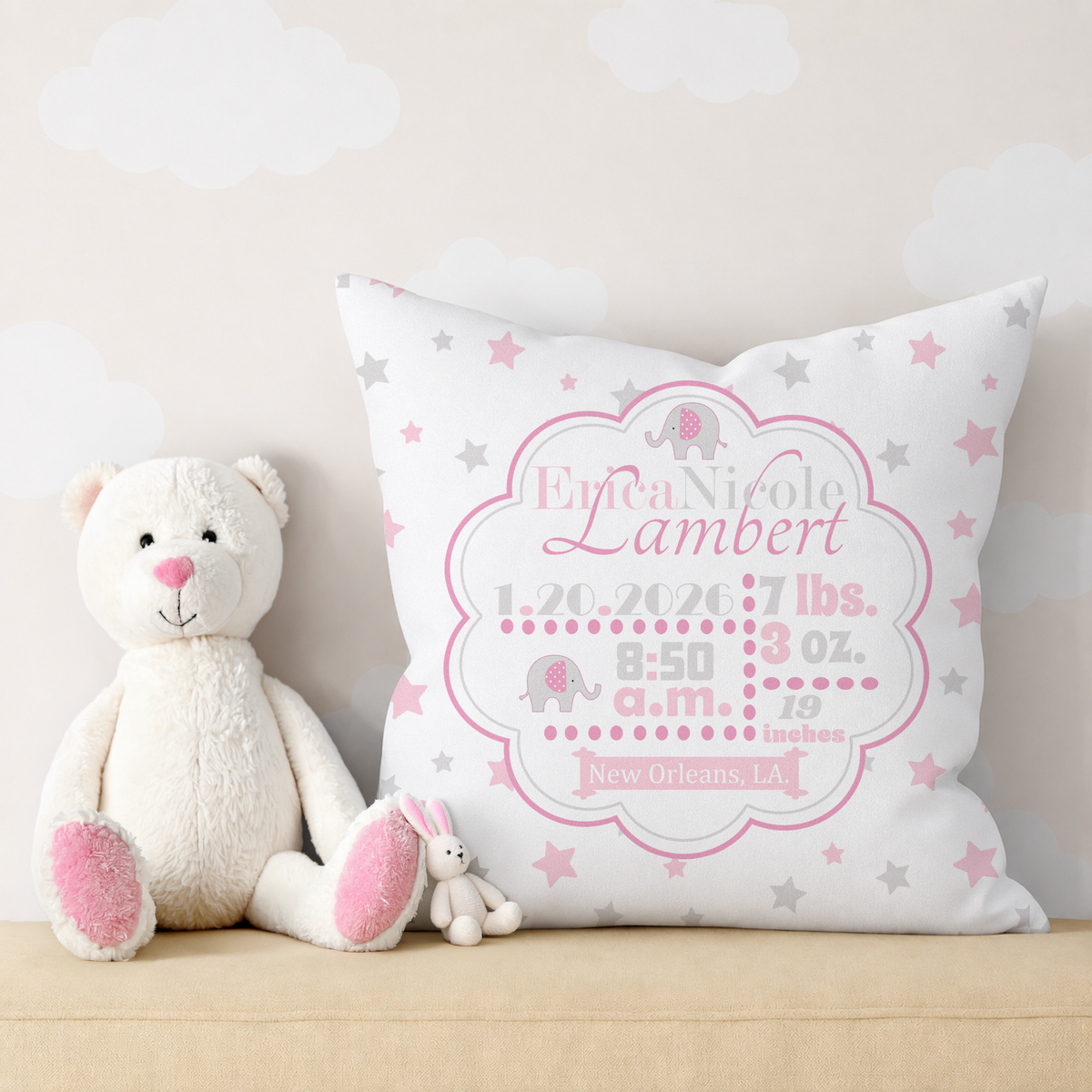 Personalized birth stats in pink pillow with baby details and a plush teddy bear on a light background