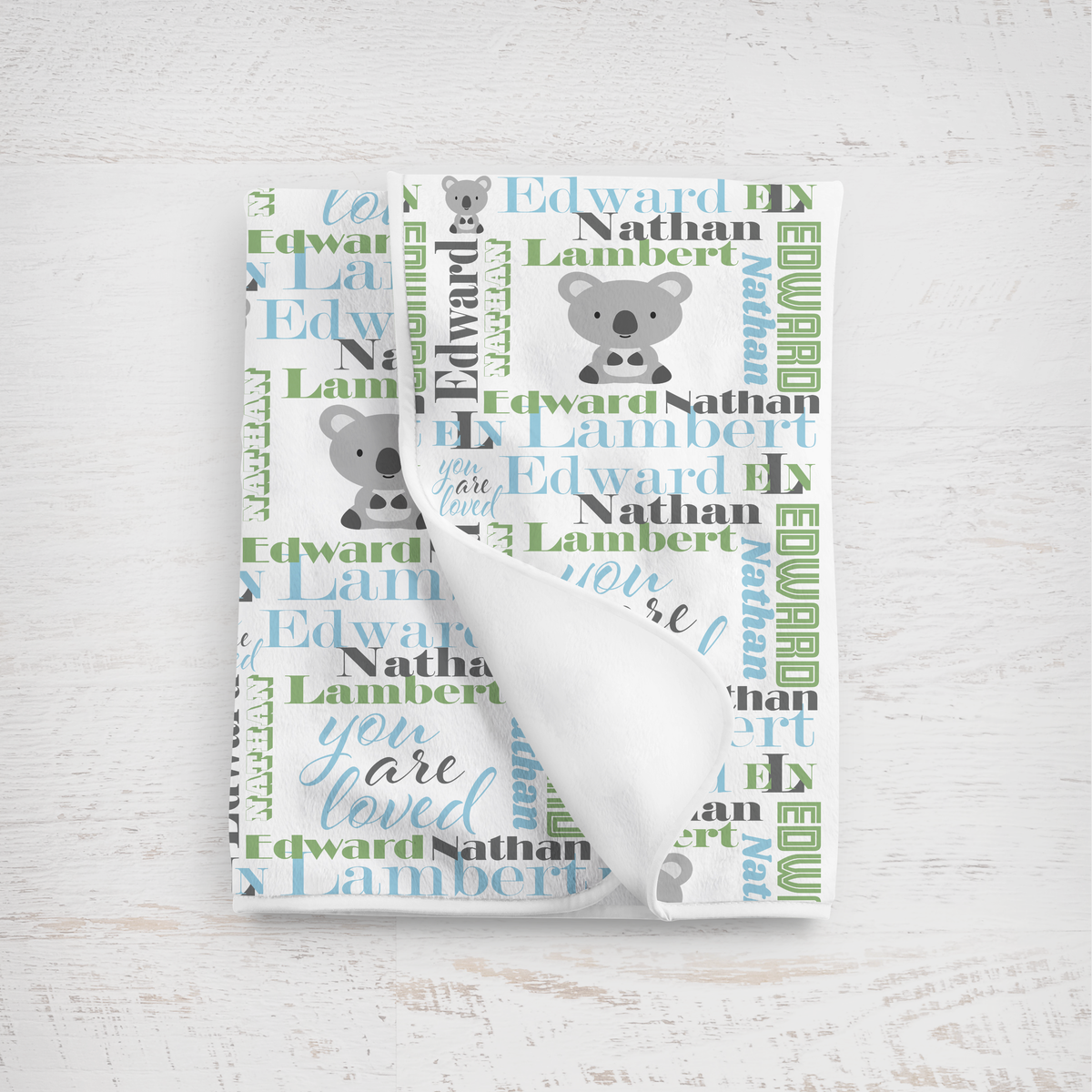 newborn baby blanket in sky blue and sage featuring a koala design against a white background