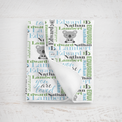 newborn baby blanket in sky blue and sage featuring a koala design against a white background