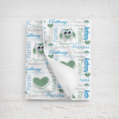 Baby blanket with owl design in green and blue colors with name text on a white background